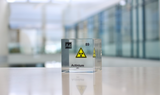 Clear acrylic cube with a suspended actinium (Ac) symbol and radioactive warning sign inside. The cube prominently displays actinium's atomic number 89, highlighting its scientific and radioactive properties in a modern, visually striking format.