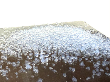 Close-up of Aerogel crystals on a surface with a white background