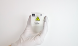 Clear acrylic cube displaying an Astatine element (Atomic Number 85) embedded within, offering a scientific presentation for collectors and science enthusiasts. Radiation symbol.