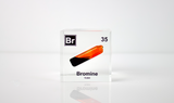 Clear acrylic cube displaying a Bromine element (Atomic Number 35) embedded within, offering a scientific presentation for collectors and science enthusiasts.