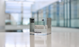Clear acrylic cube displaying a Cadmium element (Atomic Number 48) embedded within, offering a scientific presentation for collectors and science enthusiasts.