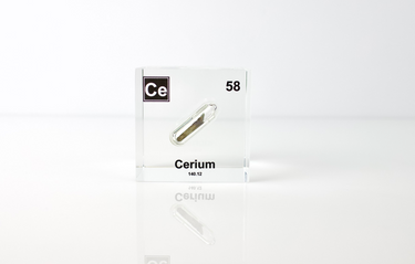 Clear acrylic cube displaying a Cerium element (Atomic Number 58) embedded within, offering a scientific presentation for collectors and science enthusiasts.