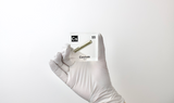 Clear acrylic cube displaying a Cesium element (Atomic Number 55) embedded within, offering a scientific presentation for collectors and science enthusiasts.
