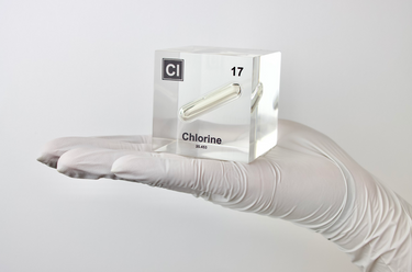 Clear acrylic cube displaying a Chlorine element (Atomic Number 17) embedded within, offering a scientific presentation for collectors and science enthusiasts.