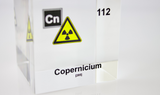 Clear acrylic cube displaying a Copernicium element (Atomic Number 112) embedded within, offering a scientific presentation for collectors and science enthusiasts.