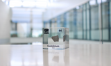 Clear acrylic cube displaying a Gadolinium element (Atomic Number 64) embedded within, offering a scientific presentation for collectors and science enthusiasts.