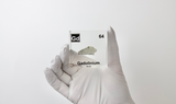 Clear acrylic cube displaying a Gadolinium element (Atomic Number 64) embedded within, offering a scientific presentation for collectors and science enthusiasts.