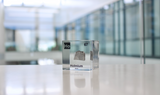 Clear acrylic cube displaying a Holmium element (Atomic Number 67) embedded within, offering a scientific presentation for collectors and science enthusiasts.