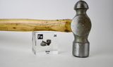 Iron element encased in a clear acrylic cube, featuring its name, atomic number, and key properties from the periodic table. Also shown with its use, a hammer. A striking and educational display for science enthusiasts and collectors