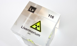 Clear acrylic cube displaying a Livermorium element (Atomic Number 116) embedded within, offering a scientific presentation for collectors and science enthusiasts.
