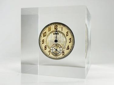 Clear acrylic display case showcasing a detailed watch face with hands and markers, offering a stylish presentation for watch enthusiasts and collectors.