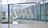 Close-up of a noble gas display made of acrylic. The display features several sections, each containing a different noble gas in its inert, gaseous form, with clear labels identifying each gas.