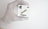 Clear acrylic cube displaying a Palladium element (Atomic Number 46) embedded within, offering a scientific presentation for collectors and science enthusiasts.