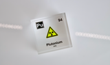 Clear acrylic cube displaying a Plutonium element (Atomic Number 94) embedded within, offering a scientific presentation for collectors and science enthusiasts.