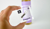 Clear acrylic cube displaying a Potassium element (Atomic Number 19) embedded within, offering a scientific presentation for collectors and science enthusiasts.
