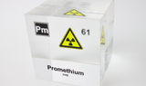 Clear acrylic cube displaying a Promethium element (Atomic Number 61) embedded within, offering a scientific presentation for collectors and science enthusiasts.
