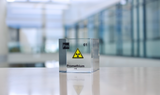 Clear acrylic cube displaying a Promethium element (Atomic Number 61) embedded within, offering a scientific presentation for collectors and science enthusiasts.