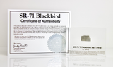 Close-up piece of SR-71 Blackbird titanium embedded in clear acrylic. The fragment is metallic and jagged, which highlights its history from the high-speed reconnaissance aircraft.