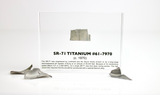 Close-up piece of SR-71 Blackbird titanium embedded in clear acrylic. The fragment is metallic and jagged, which highlights its history from the high-speed reconnaissance aircraft.