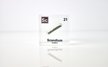 Clear acrylic cube displaying a Scandium element (Atomic Number 21) embedded within, offering a scientific presentation for collectors and science enthusiasts.