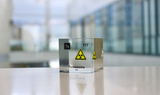 Clear acrylic cube displaying a Tennessine element (Atomic Number 117) embedded within, offering a scientific presentation for collectors and science enthusiasts.