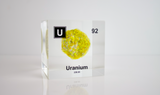 Clear acrylic cube showcasing a Uranium element (Atomic Number 92) embedded within, offering a scientific display for collectors and science enthusiasts.