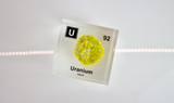 Clear acrylic cube showcasing a Uranium element (Atomic Number 92) embedded within, offering a scientific display for collectors and science enthusiasts.