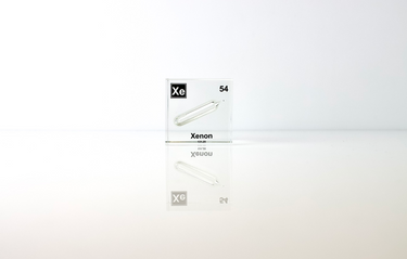 Clear acrylic cube displaying a Xenon element (Atomic Number 54) embedded within, offering a scientific presentation for collectors and science enthusiasts.
