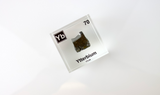 Clear acrylic cube displaying an Ytterbium element (Atomic Number 70) embedded within, offering a scientific presentation for collectors and science enthusiasts.