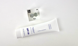 Zinc element encased in a clear acrylic cube, featuring its name, atomic number 30, and properties as displayed on the periodic table. Ideal for educational and collector use. Sunscreen, as a mass use being zinc oxide, sits next to the cube.