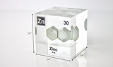 Zinc element encased in a clear acrylic cube, featuring its name, atomic number 30, and properties as displayed on the periodic table. Specifically showing its dimensions Ideal for educational and collector use.