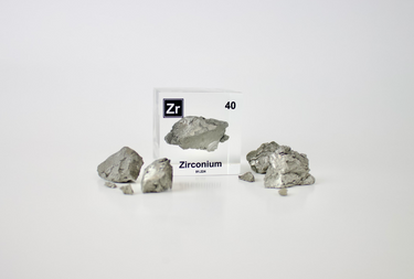 Clear acrylic cube displaying a Zirconium element (Atomic Number 40) embedded within, offering a scientific presentation for collectors and science enthusiasts.