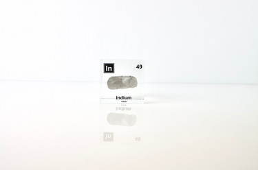 Clear acrylic cube displaying an Indium element (Atomic Number 49) embedded within, offering a scientific presentation for collectors and science enthusiasts.