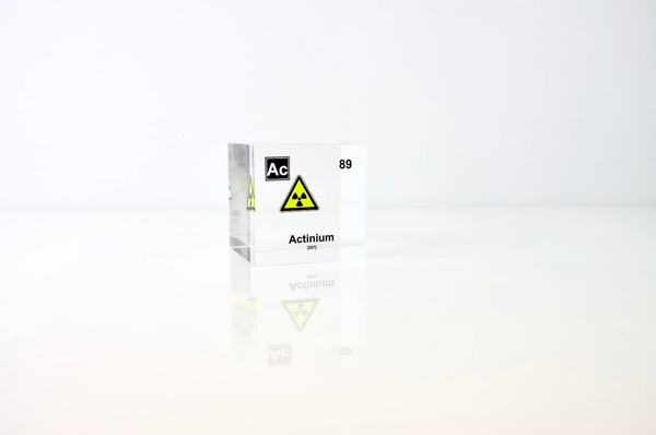 Clear acrylic cube displaying an Actinium element (Atomic Number 89) embedded within, offering a scientific presentation for collectors and science enthusiasts.