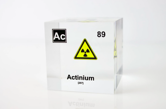 Clear acrylic cube displaying an Actinium element (Atomic Number 89) embedded within, offering a scientific presentation for collectors and science enthusiasts.