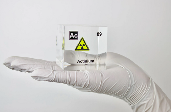 Clear acrylic cube displaying an Actinium element (Atomic Number 89) embedded within, offering a scientific presentation for collectors and science enthusiasts.