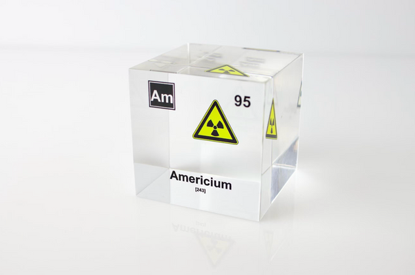 Clear acrylic cube displaying an Americium element (Atomic Number 95) embedded within, offering a scientific presentation for collectors and science enthusiasts. Radiation symbol.