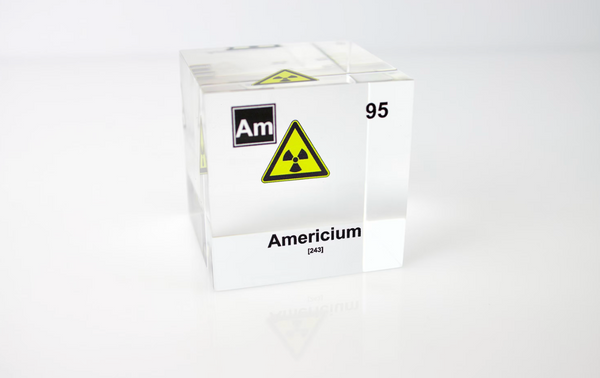 Clear acrylic cube displaying an Americium element (Atomic Number 95) embedded within, offering a scientific presentation for collectors and science enthusiasts. Radiation symbol.