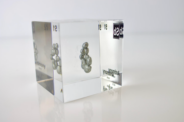 Clear acrylic cube displaying an Antimony element (Atomic Number 51) embedded within, offering a scientific presentation for collectors and science enthusiasts.