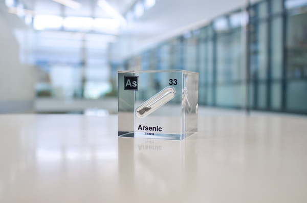 Arsenic element encased in a clear acrylic cube, showcasing its name, atomic number 33, and key properties from the periodic table. An informative and visually striking piece ideal for educational purposes and collectors.