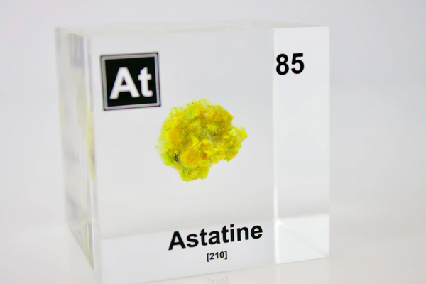 Clear acrylic cube displaying an Astatine element (Atomic Number 85) embedded within, offering a scientific presentation for collectors and science enthusiasts.