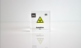 Clear acrylic cube displaying an Astatine element (Atomic Number 85) embedded within, offering a scientific presentation for collectors and science enthusiasts. Radiation symbol.