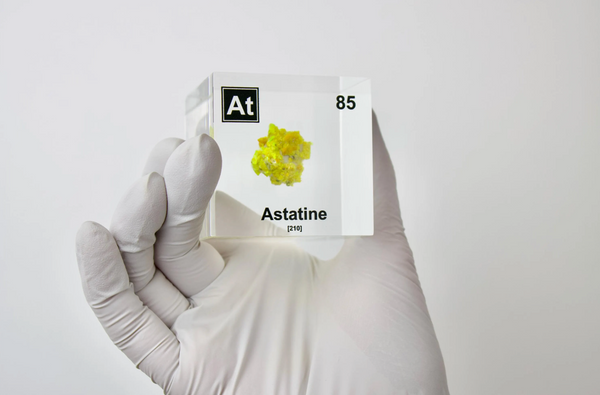 Clear acrylic cube displaying an Astatine element (Atomic Number 85) embedded within, offering a scientific presentation for collectors and science enthusiasts.