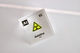 Clear acrylic cube displaying an Astatine element (Atomic Number 85) embedded within, offering a scientific presentation for collectors and science enthusiasts. Radiation symbol.