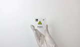 Clear acrylic cube displaying a Berkelium element (Atomic Number 97) embedded within, offering a scientific presentation for collectors and science enthusiasts. Radiation symbol.