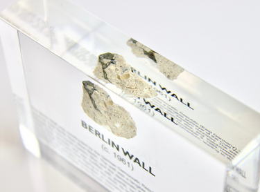 Clear acrylic display case featuring a historical fragment of the Berlin Wall, providing an authentic and educational presentation for history enthusiasts and collectors.