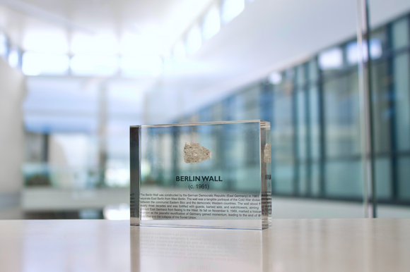 Clear acrylic display case featuring a historical fragment of the Berlin Wall, providing an authentic and educational presentation for history enthusiasts and collectors.