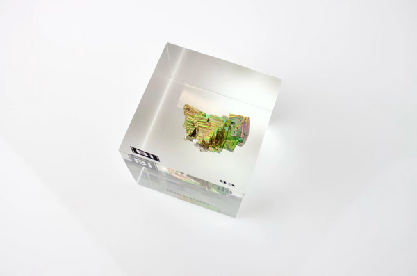 Clear acrylic cube displaying a Bismuth element (Atomic Number 83) embedded within, offering a scientific presentation for collectors and science enthusiasts.