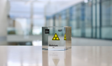 Clear acrylic cube displaying a Bohrium element (Atomic Number 107) embedded within, offering a scientific presentation for collectors and science enthusiasts. Radiation symbol.