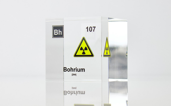 Clear acrylic cube displaying a Bohrium element (Atomic Number 107) embedded within, offering a scientific presentation for collectors and science enthusiasts. Radiation symbol.